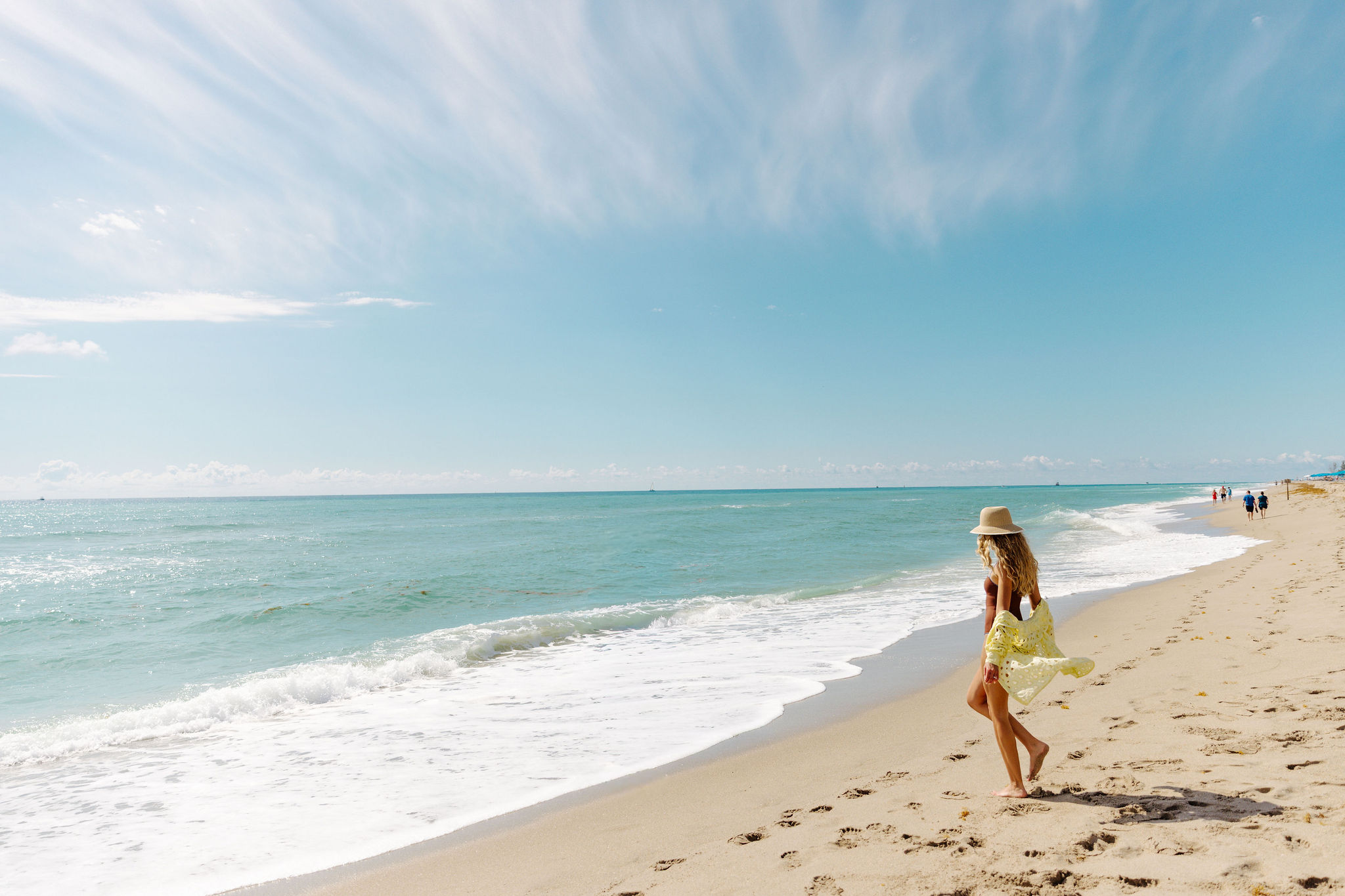 woman walking towards ocean waves