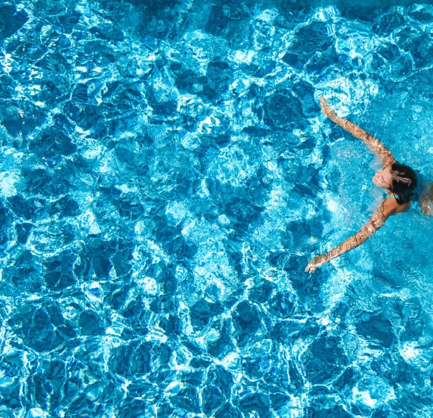 A woman at an infinite pool enjoying resort lifestyle