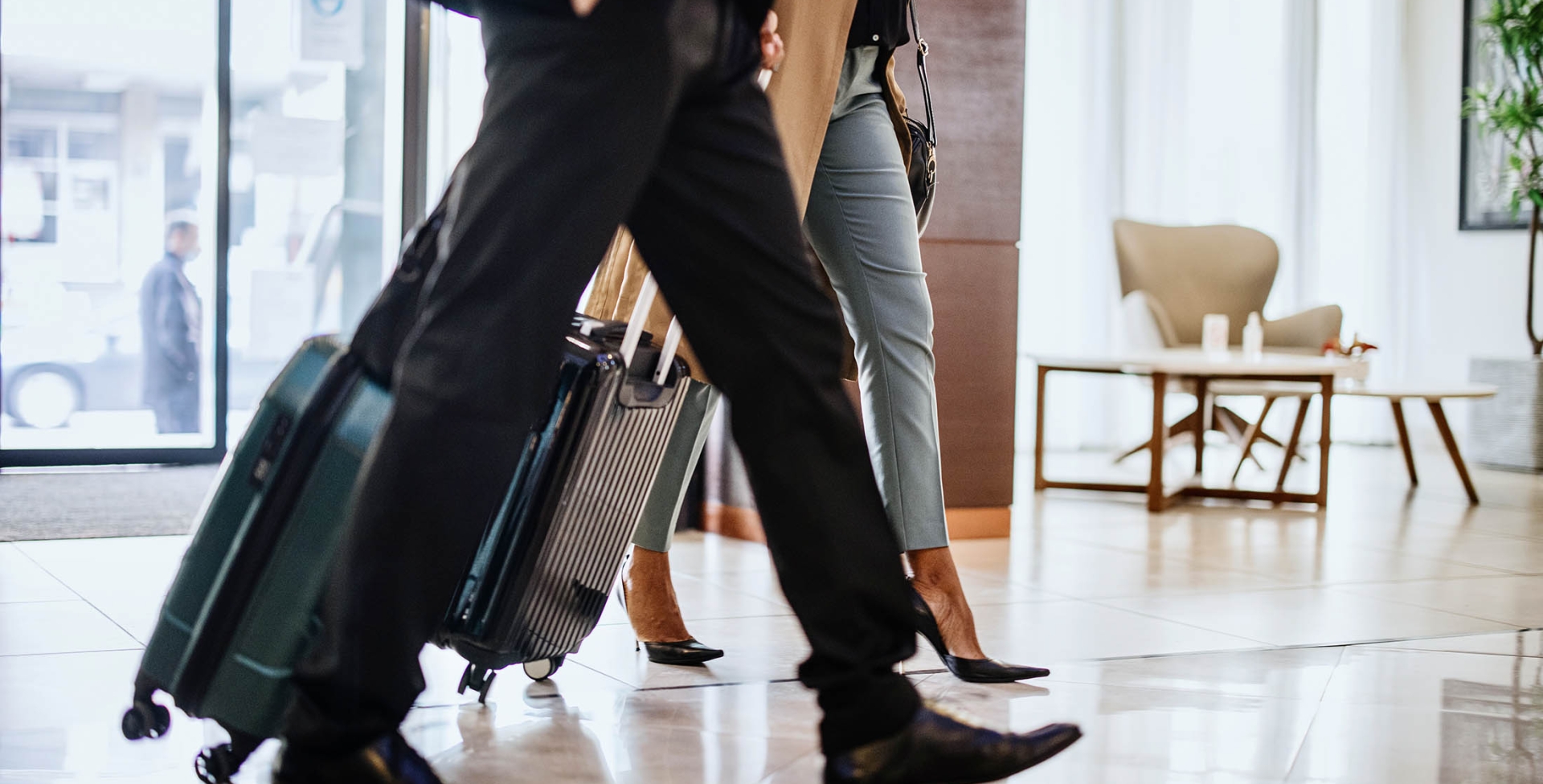 Business travellers with suitcases walking