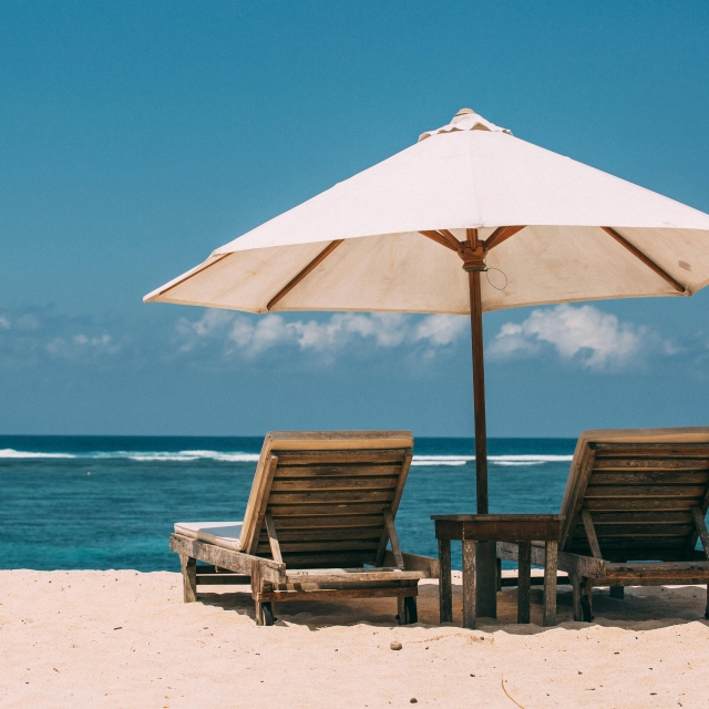 beach umbrella and chairs facing the ocean