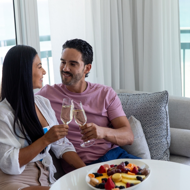 young couple holding champagne glasses in hotel room