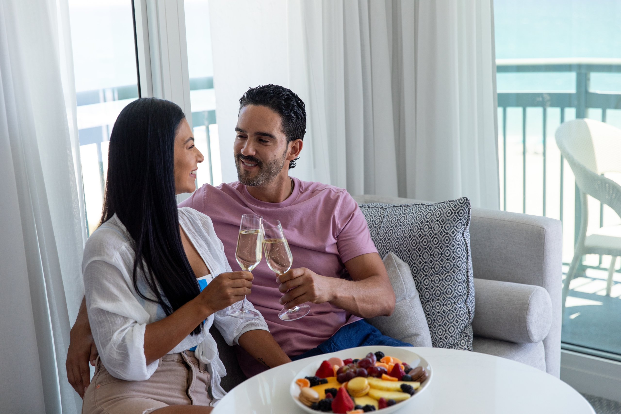 young couple holding champagne glasses in hotel room